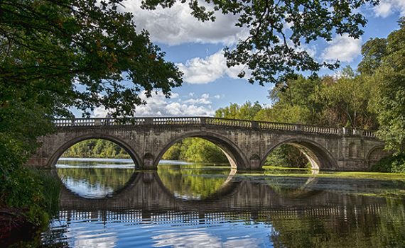 Ponte in pietra sul lago con riflesso